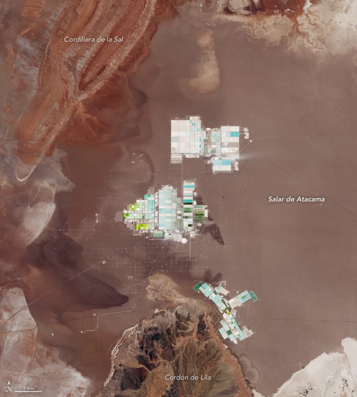 Satellite view of the geometric evaporation ponds at Chile’s Salar de Atacama, surrounded by the desert landscape.